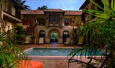 an outdoor swimming pool surrounded by palm trees