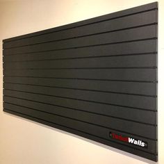 a black wall mounted sign on the side of a white wall in an office building