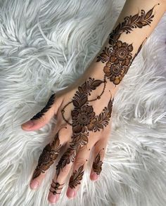 a woman's hand with henna tattoos on it