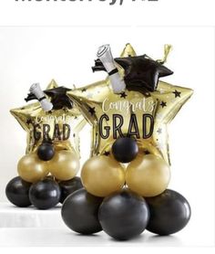 some black and gold balloons are in the shape of stars with congratulations written on them