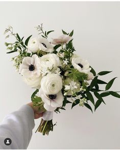 a person holding a bouquet of white flowers