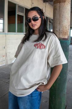 a woman wearing sunglasses and a t - shirt Cotton Short Sleeve T-shirt For Sports Season, Casual T-shirt With Front Print For Sports Events, Sporty Screen Print T-shirt For Streetwear, Relaxed Fit Sports T-shirt With Text Print, Sporty Cotton T-shirt With Front Print, Sporty T-shirt With Front Print And Relaxed Fit, Short Sleeve Graphic Print T-shirt For Sports, Sports Season Graphic Print Short Sleeve T-shirt, Sporty Short Sleeve T-shirt With Sublimation Print