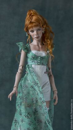 a doll with red hair wearing a green dress