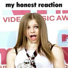 a woman holding an award in front of a sign that says, my honest reaction video music awards