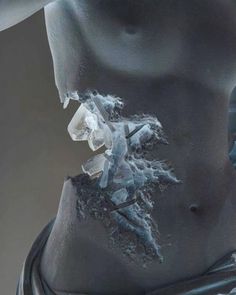 an abstract photo of a woman's torso with ice crystals embedded in her stomach