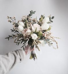 a person holding a bouquet of flowers in their hand