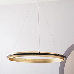 a circular light fixture hanging from a ceiling in a room with white walls and flooring