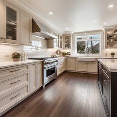 a large kitchen with white cabinets and wood floors is pictured in this image from the front view