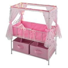 a pink baby crib with two storage bins and lights on the top shelf