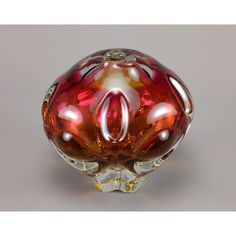 a red and white glass vase sitting on top of a table