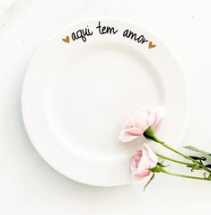 two pink roses sitting on top of a white plate that says, i love you mom