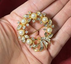 Beautiful Lisner wreath and bow circle brooch with white faux pearls and clear rhinestones with a bow on a gold base.  2" diameter Elegant Round Brooches With Rhinestones, Elegant Round Rhinestone Brooches, Rhinestone Jewelry, Clear Rhinestones, Vintage Brooches, Lincoln, Faux Pearl, Halloween Shopping, Brooch Pin