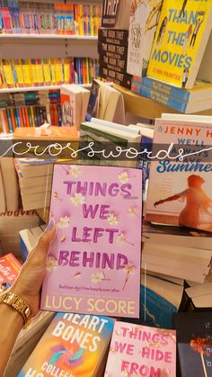 a person holding up a book in front of a pile of books