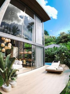 an outdoor living room with large windows and plants in the foreground, next to a swimming pool