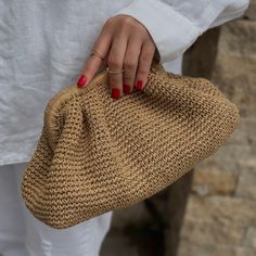 a woman's hand holding a straw purse