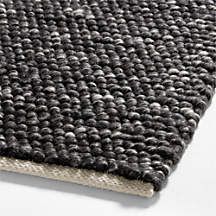 a close up view of a black rug on a white surface with no one in it