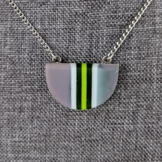 One of a kind handmade fused glass pendant. Simple and elegant modern minimalist style Transparent green gray and with stripes with geometric shape. Size: 30mm x 20mm x 6mm. Cast silver necklace attachments. Incorporates Bullseye opal and transparent glass. Sculpted by hand and fused multiple times. Includes nickle free hypoallergenic 18 inch attached chain. Message anytime with questions. -Sean Minimalist Green Glass Jewelry, Modern Green Necklace With Round Pendant, Modern Green Round Pendant Necklace, Slumped Glass, Fused Glass Necklace, Dichroic Glass Jewelry, Modern Minimalist Style, Fused Glass Pendant, Fused Glass Jewelry