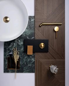 a white sink sitting next to a wooden door with gold handles and knobs on it