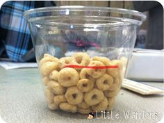 a glass cup filled with cereal sitting on top of a table