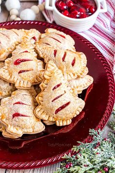 a plate full of cherry hand pies with cranberry sauce in the background