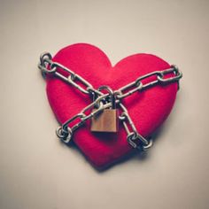 a red heart with chains and a padlock attached to it