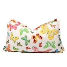 a white pillow with colorful butterflies printed on the front and back, sitting on a white surface