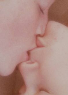 a close up of a person kissing a baby