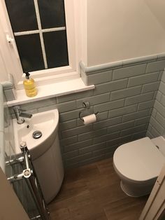 a white toilet sitting next to a window in a bathroom