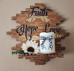 a wooden sign that says faith hope love and a candle with a sunflower on it