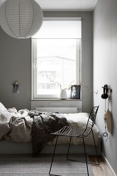 a bed sitting in a bedroom under a window next to a radiator and lamp