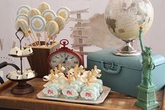 an assortment of desserts on a table in front of a world map and statue of liberty