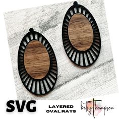 two wooden earrings with black and white designs on the front, one is shaped like an oval