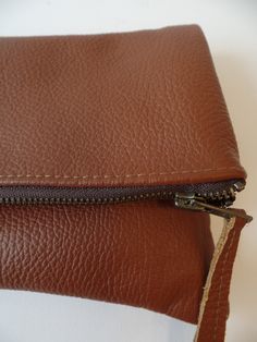 Genuine real leather brown simple everyday foldober zippered clutch bag. *Exterior High quality buttery soft supple pebbled real genuine leather. *interior - Fully lined with 100% natural cotton in chocolate brown. * Closes with YKK antique gold toned metal zipper closure. Approx. measurments (unfolded): Width -12 inches Height- 11.5 inches Simple Leather Bag, Brown Clutch, Foldover Clutch, Knitting Project Bag, Leather Clutch Bag, Zippered Clutch, Simple Leather, Leather Clutch Bags, Brown Bags