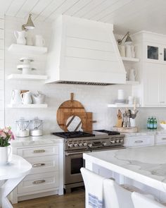 a kitchen with white cabinets and counter tops