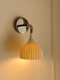 a wall light that is on the side of a wall next to a mirror and door