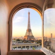 the eiffel tower is seen through an arched window