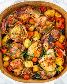 chicken, potatoes and carrots in a casserole dish on a marble surface