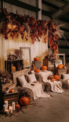 pumpkins and hay bales are arranged on the floor