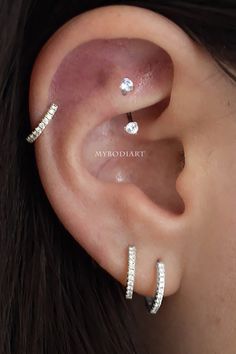 a woman wearing three different ear piercings on her left and right side of the ear