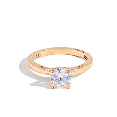 a yellow gold ring with a white diamond