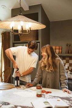 a man and woman are in the kitchen preparing food