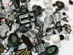 a pile of glass beads and other items sitting on top of a white tablecloth