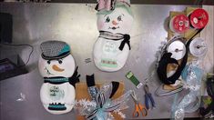 several snowmen are hanging on the wall next to some scissors and other items that have been placed around them