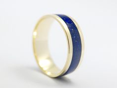 Here is a beautiful lapis gold band from fierbijou! This minimalist solid gold band is inlaid with chipped lapislazuli stones and the band is created using 8/14/18K solid gold. The ring pictured here is 8K, 7mm wide and 1.2 mm thick. Inlay is 3.5mm wide and there is a durable, waterproof coating on it. The coating has a smooth and shiny surface that is level with gold which provides comfortable wear and creates a good contrast between the beautiful ultramarine blue hue of the lapis and yellow go Yellow Gold Lapis Lazuli Gemstone Rings, Yellow Gold Rings With Lapis Lazuli Gemstone, Yellow Gold Lapis Lazuli Ring With Polished Finish, Yellow Gold Lapis Lazuli Minimalist Jewelry, Minimalist Yellow Gold Lapis Lazuli Jewelry, Anniversary Yellow Gold Lapis Lazuli Jewelry, Polished Yellow Gold Lapis Lazuli Jewelry, Yellow Gold Lapis Lazuli Jewelry With Polished Finish, Gold Rings With Lapis Lazuli Gemstone