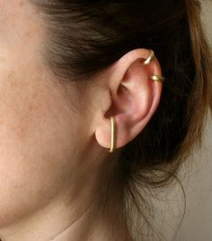 Modern, minimalist ear cuff set of two. No piercing needed. They are made from 3mm half-rounded brass wire. Brass is an alloy of copper and zinc - the proportions of the two differ to create different kinds of brass that range in degree of yellow-color. If you have a nickel allergy, you are very unlikely to be allergic to brass since there is no nickel in it at all. The cuffs are cut and textured by hand to a mat finish. Choose the combo you like and wear them all day long. See the matching earr Conch Cuff, Minimalist Ear Cuff, Helix Ear, Huggie Earring, Wrap Earrings, Gold Ear Cuff, Dope Jewelry, Pierced Jewelry, Beaded Hoops