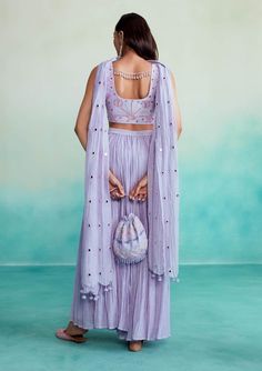 Introducing the luminova crop-top & sharara set in lavender! This exquisite ensemble is crafted from soft chanderi fabric, ensuring both comfort and elegance. The crop-top features hand-embroidered motifs inspired by kutch's rich heritage, blending tradition with a modern design. The set includes a micro-pleated sharara and a mirror work dupatta with handmade hangings, adding a delightful sparkle to your look. Purple Palazzo Set With Sheer Dupatta For Diwali, Festive Lavender Choli With Sheer Dupatta, Lavender Sets With Dupatta For Eid, Lavender Eid Outfit Set With Dupatta, Lavender Eid Sets With Dupatta, Lavender Eid Set With Dupatta, Summer Sharara With Unstitched Blouse In Georgette, Lavender Saree Set With Resham Embroidery, Festive Anarkali Set In Lavender