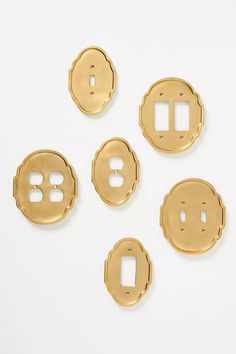 four brass - plated metal switch plates