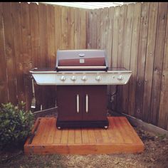 a bbq grill sitting on top of a wooden platform