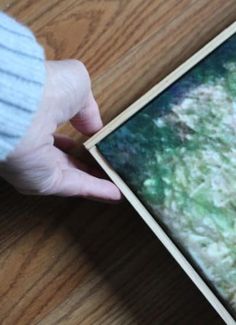 a person holding an old photo on a wooden table