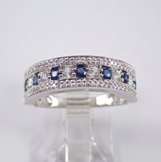 14K White Gold Diamond and Sapphire wedding ring anniversary band. This wedding ring is set with thirty-one genuine Round Brilliant Diamonds, six Round White Sapphires and seven natural round Blue Sapphires. These diamonds are G color, SI clarity and weigh a total of .15 carat. The Sapphires in this ring amount to a total weight of .40 carat. This ring is 14KT White Gold, weighs 3.6 grams, measures 6 mm in width at its widest and is a finger size 7, can be resized free of charge. This ring will also be accompanied by an appraisal by a GIA Certified Diamond Grader with the replacement value of $1,495.00. I will ship this ring promptly in a beautiful gift box. ADDITIONAL REQUESTS If you would like to see more pictures of this item, please let us know and we would be happy to provide them for Gold Anniversary Bands, Sapphire Wedding Rings, White Gold Sapphire, Sapphire Wedding, Anniversary Bands, Brilliant Diamond, Pretty Earrings, White Sapphire, Conflict Free Diamonds